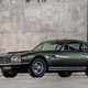 A photo of a dark green Aston Martin DBS sports car from the 1960s.